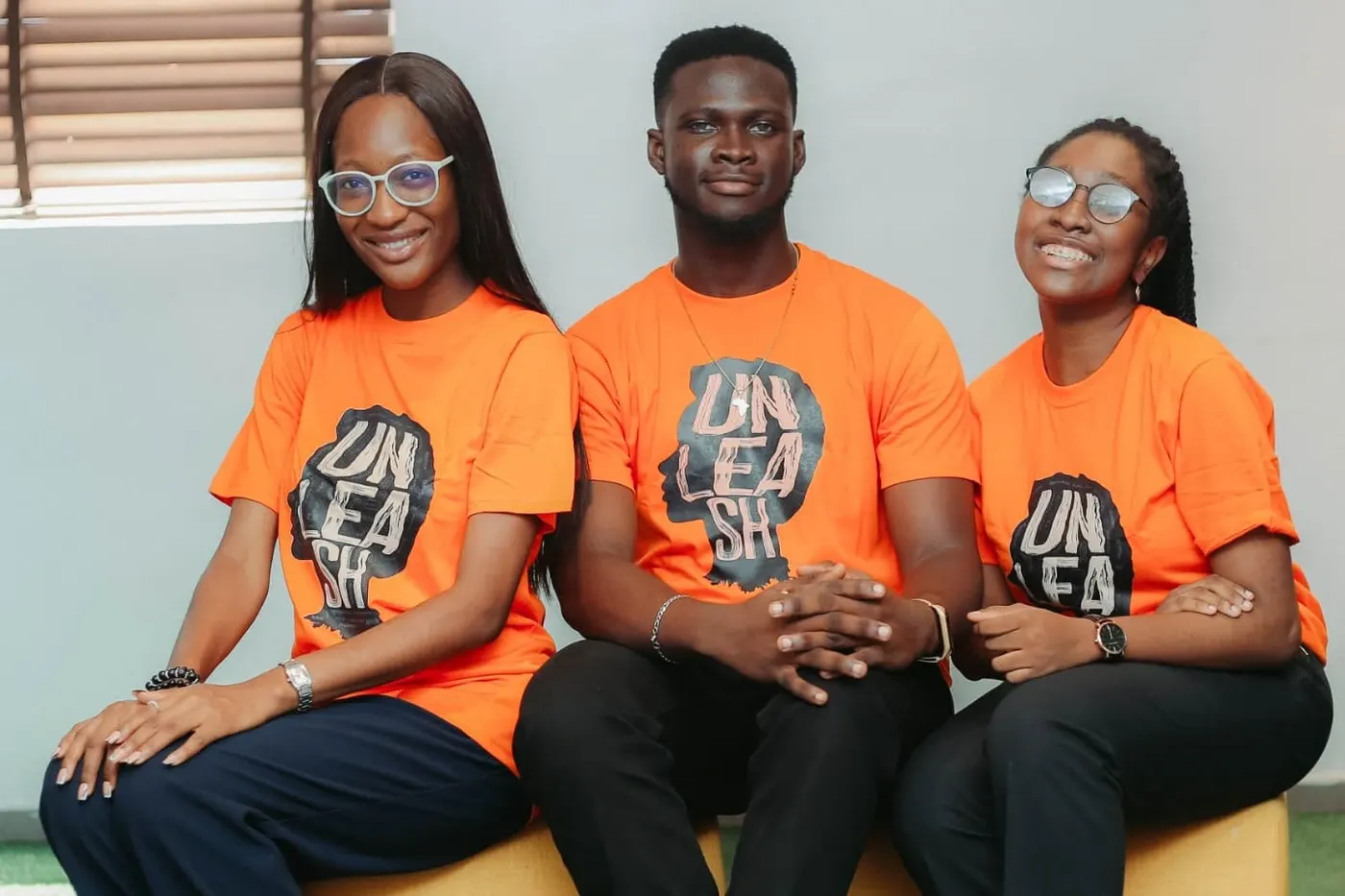 Three young professionals in UNLEASH t-shirts
